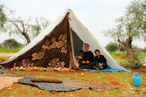 A family sitting near a tent in a rural area reached by Pararthya SDECS