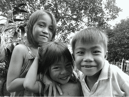 Two children smiling warmly at a Pararthya SDECS community event